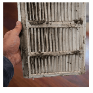 Dirty return vent cover with visible dust buildup removed for cleaning