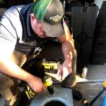 Man repairing equipment with drill